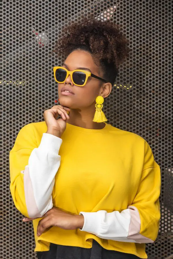 woman wearing a yellow shirt and yellow accessories showing how to create a color coordinated wardrobe